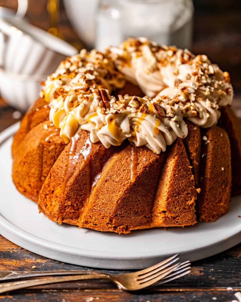 Sweet Potato Pound Cake with Maple Cream Cheese Frosting sweet potato pound cake on a serving plate topped with buttermilk syrup and cream cheese frosting.